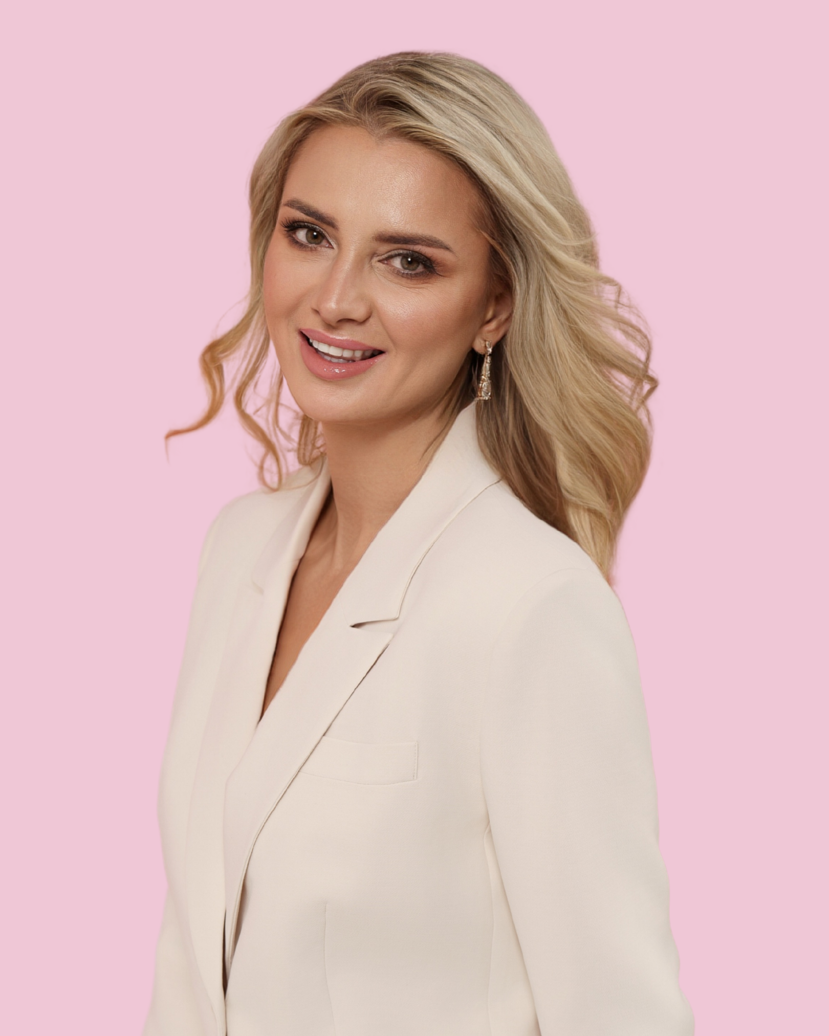 Mila Rymsza – właścicielka Beauty Place and School, ekspertka branży beauty w eleganckiej białej marynarce na różowym tle