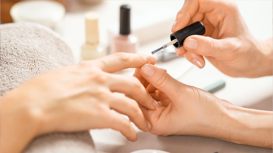 Kobieta z zadbanymi dłońmi i naturalnym manicure w gabinecie